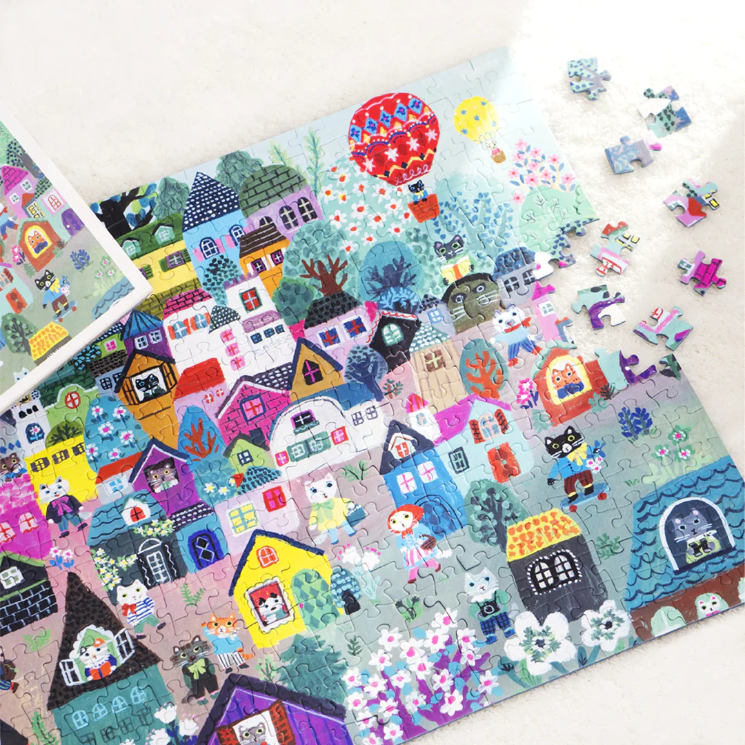 Kolorowe puzzle artystyczne 500 elementów przedstawiające urokliwą wiejską wioskę z domami i balonem