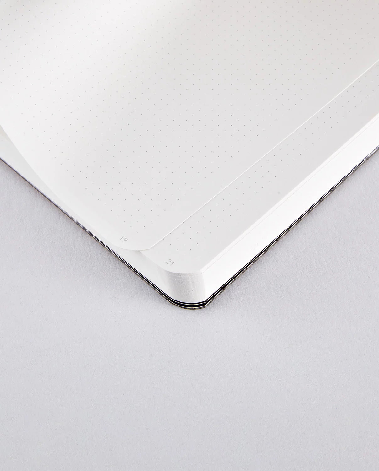 Notatnik miedziany z BV JACOB COMPANY otwarty na kropkowanych białych stronach