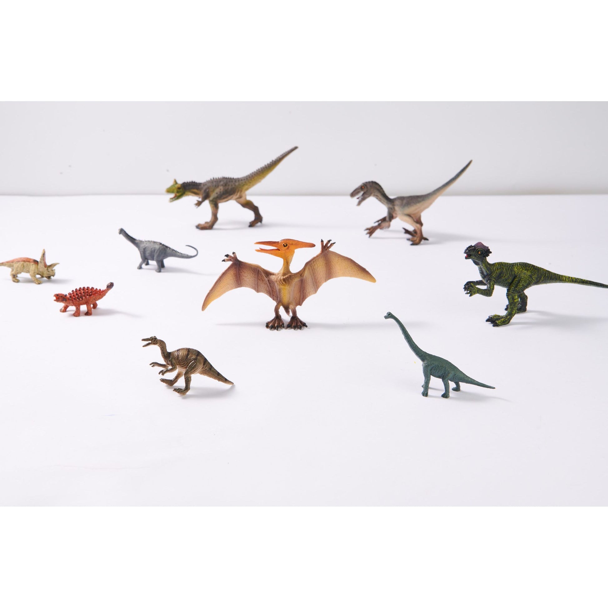 Zestaw figurek dinozaurów dla dzieci w różnych kolorach i pozach na białym tle