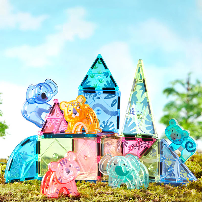 Kolorowe klocki magnetyczne zwierzęta WABOBA AB ułożone na trawie na tle nieba