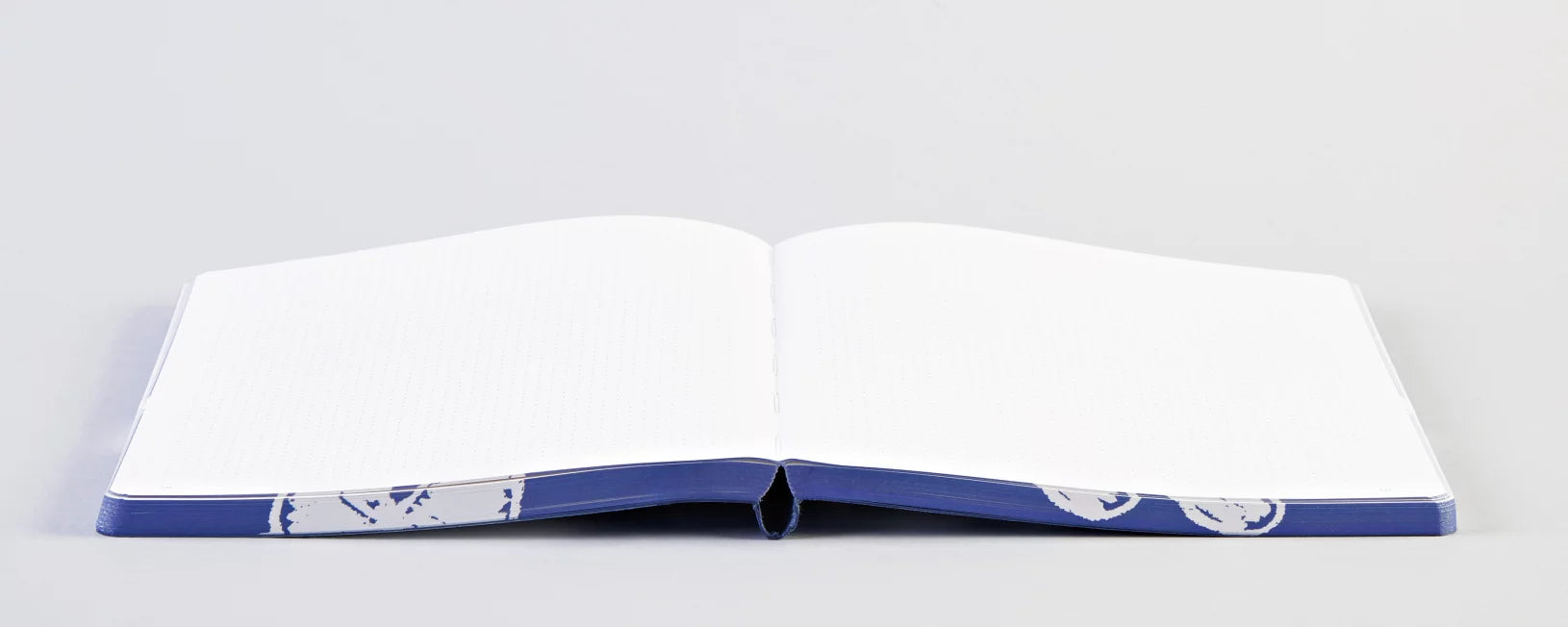 Otwarty notatnik z chmurami o niebieskiej okładce od BV JACOB COMPANY z pustymi stronami