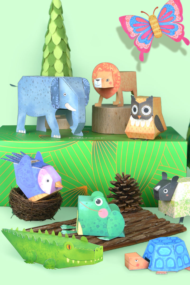 Kolorowe origami papierowe zwierzęta Yamann z realistycznymi detalami na zielonym tle