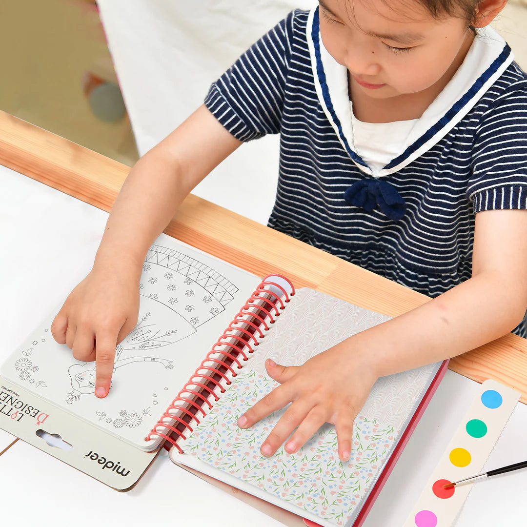 Dziecko korzystające z zeszytu kreatywnego dla dzieci marki Yamann przy stole do malowania