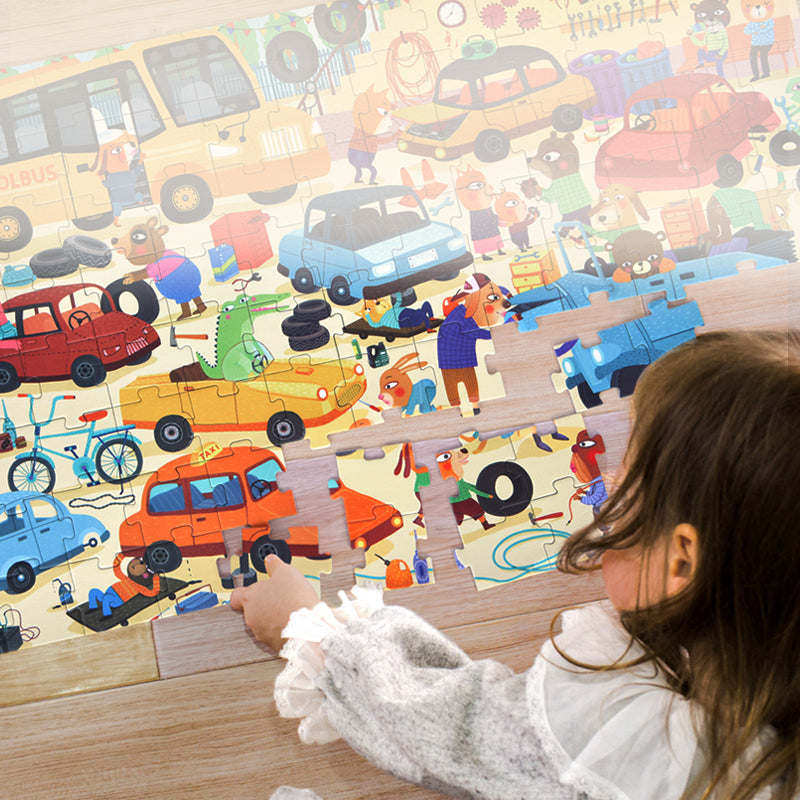 Dziecko składa kolorowe puzzle dla dzieci w walizce z obrazkami samochodów i zwierząt