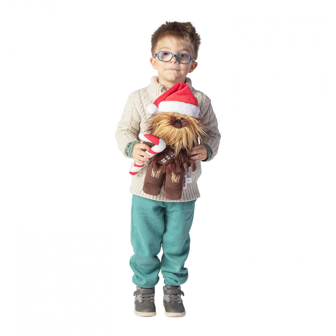 Chłopiec w okularach trzymający pluszak LEGO Star Wars Chewbacca świąteczny z czapką Mikołaja i lizakiem