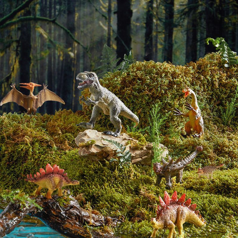 Zestaw figurek dinozaurów dla dzieci przedstawiający różne gatunki dinozaurów na tle leśnym z mchem