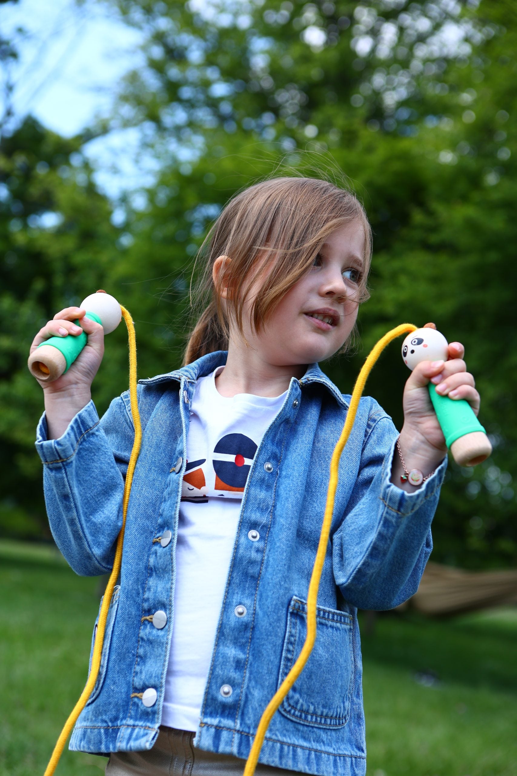 Dziecko bawiące się skakanką dla dzieci panda marki mideer z uchwytami w kształcie pandy na zewnątrz