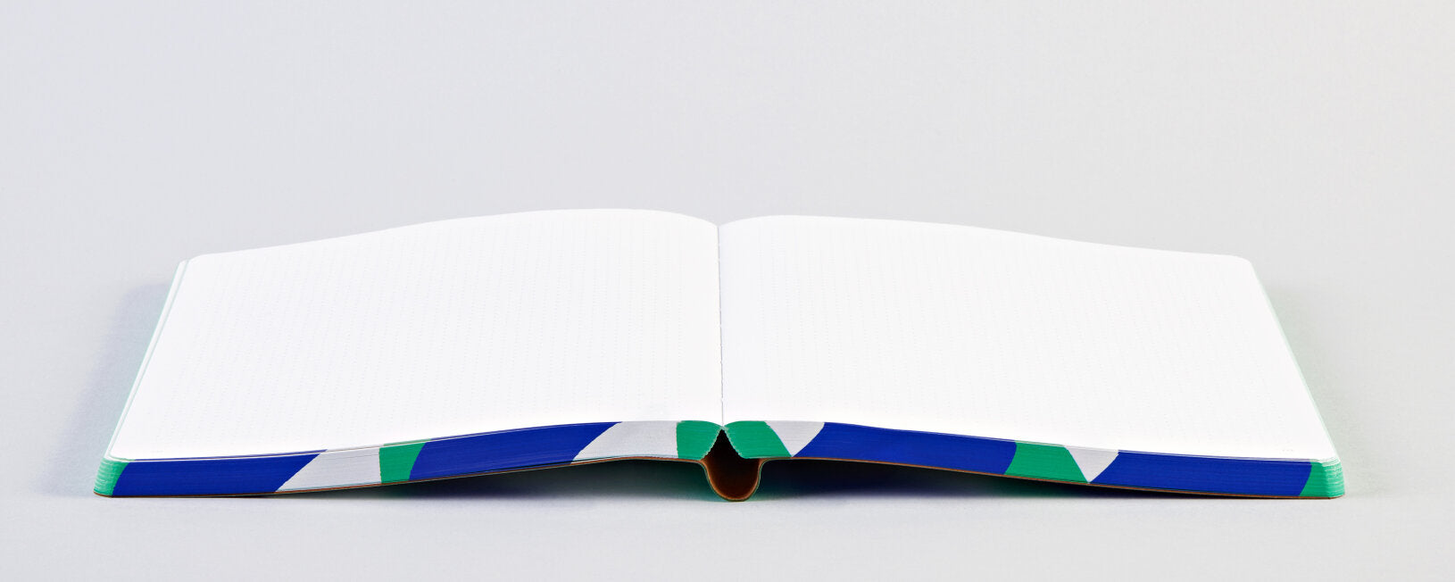 Otwarty notatnik graficzny L firmy BV JACOB COMPANY z białymi kartkami i kolorową oprawą