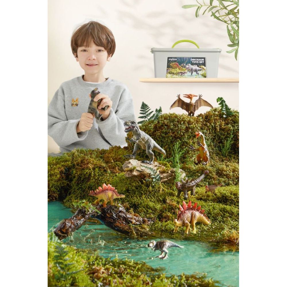 Zestaw figurek dinozaurów dla dzieci z różnymi plastikowymi dinozaurami i chłopcem bawiącym się nimi