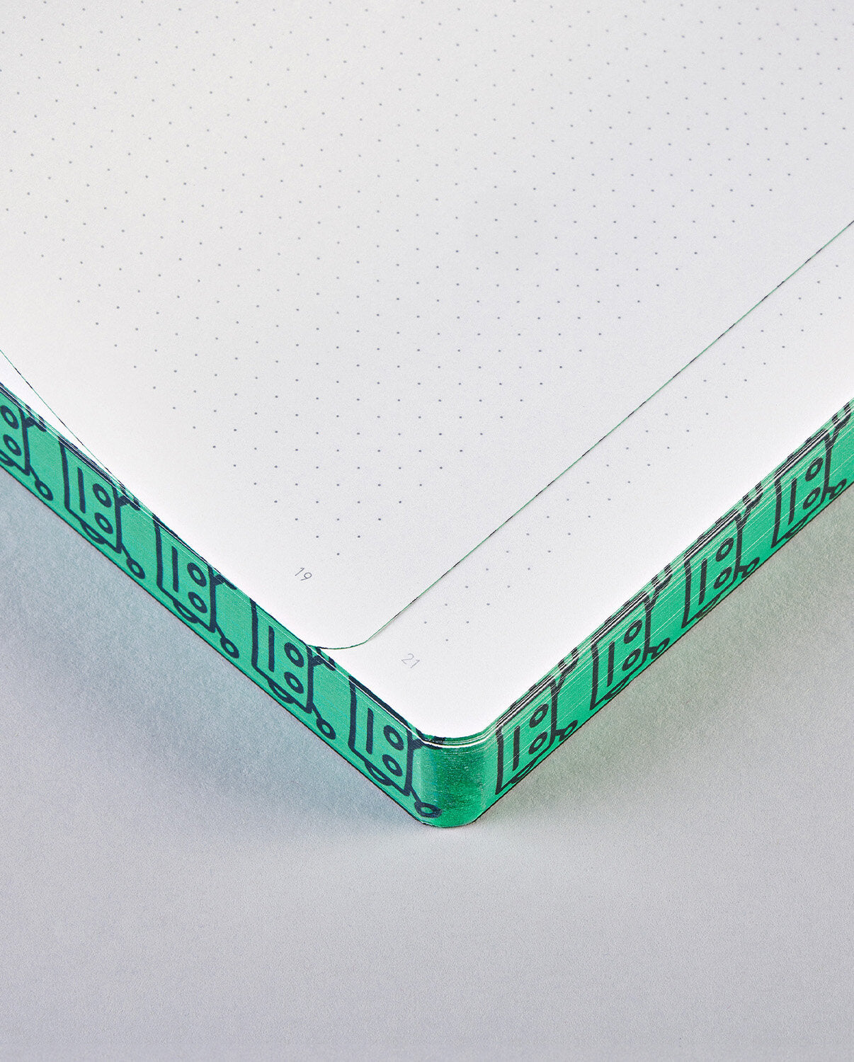 Notatnik Write Against The Machines z kartkami w kropki i zieloną obwolutą z wzorem robotów