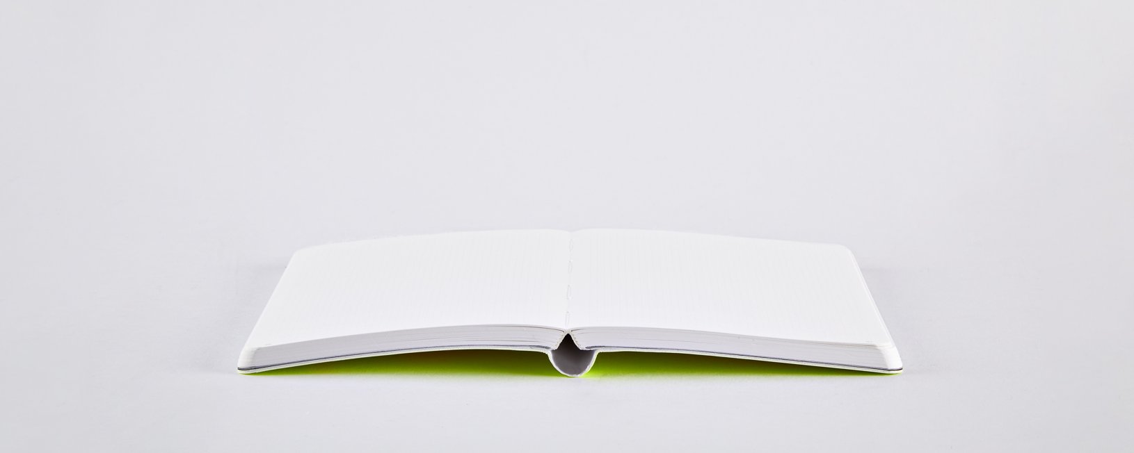 Notatnik neonowy żółty otwarty na białym tle z pustymi stronami do pisania