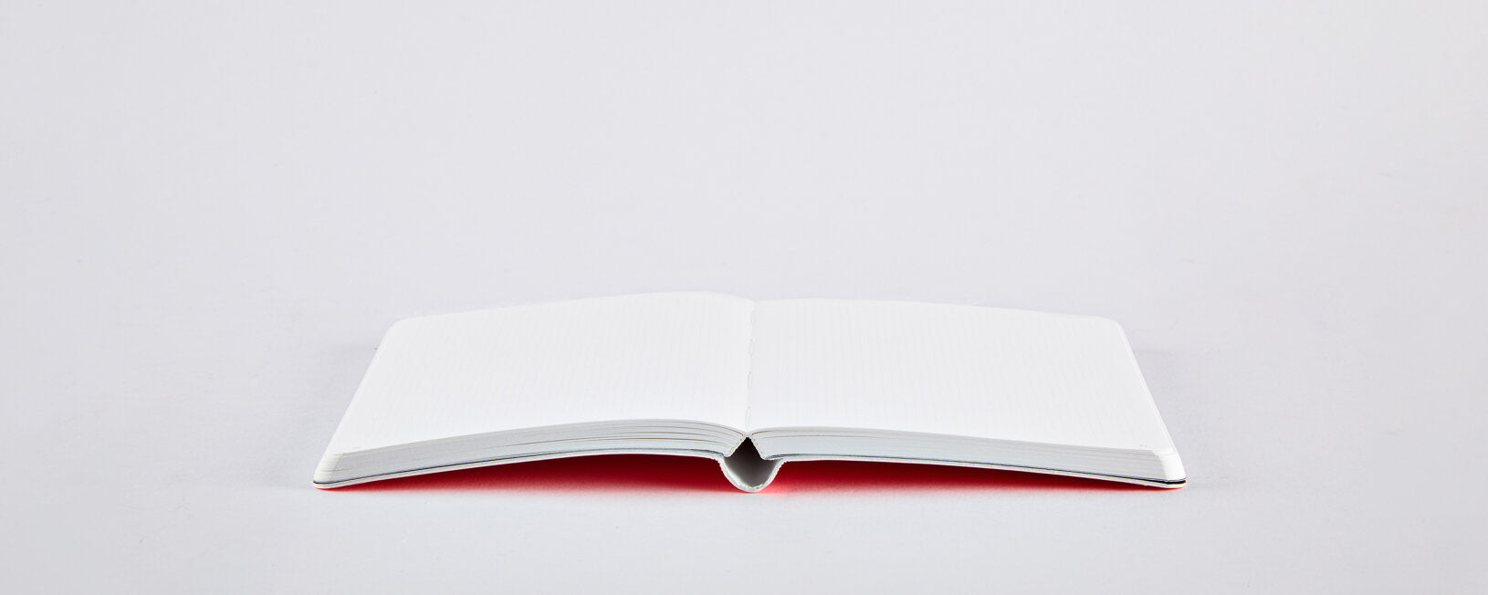 Notatnik neonowy różowy BV JACOB COMPANY otwarty na białym tle z pustymi stronami