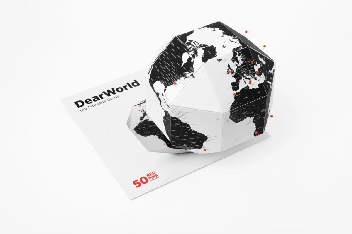 Globus z pinezkami od WABOBA AB w czarno-białych kolorach na białym tle