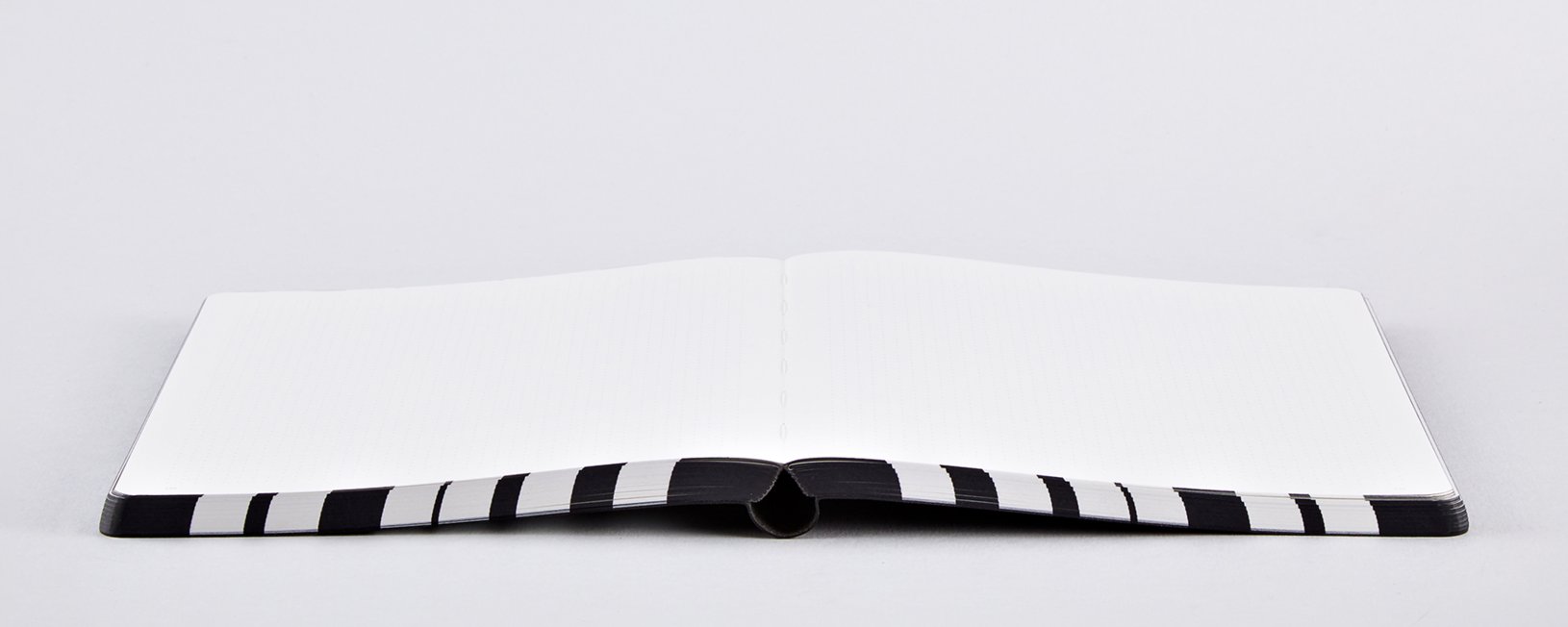 Otwarty notatnik graphic L od Yamann z czarno-białą oprawą i pustymi kartkami