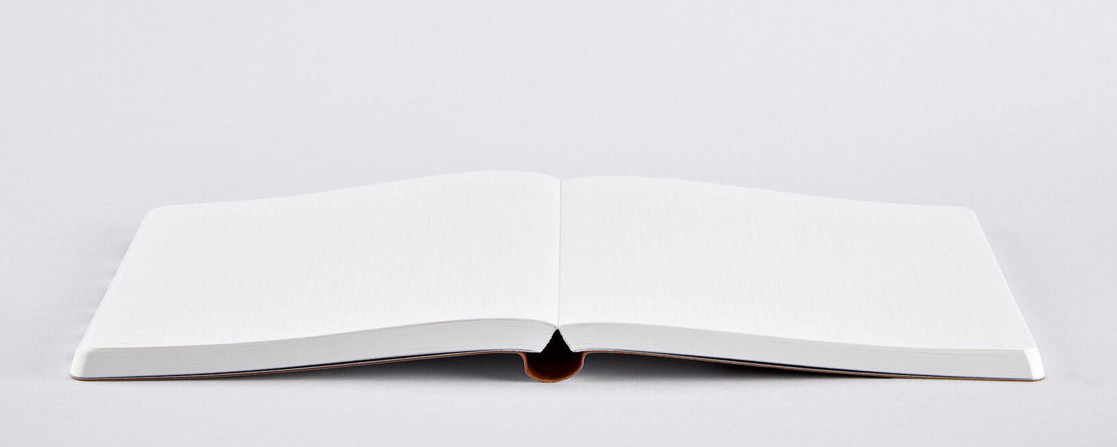 Otwarto notatnik graphic L z czystymi białymi kartkami na szarym tle