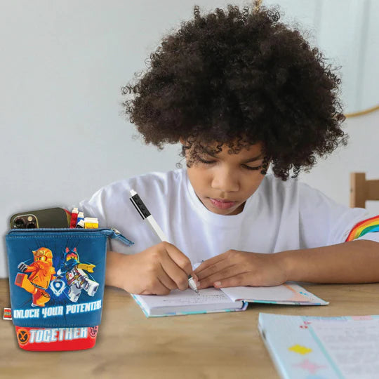 Dziecko piszące przy biurku z piórnikiem LEGO Ninjago pełnym przyborów do szkoły