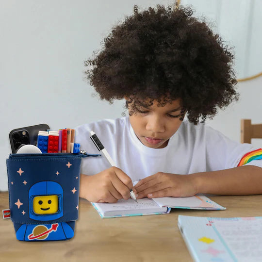 Niebieski piórnik LEGO astronauta niebieski z motywem kosmonauty obok dziecka piszącego w zeszycie