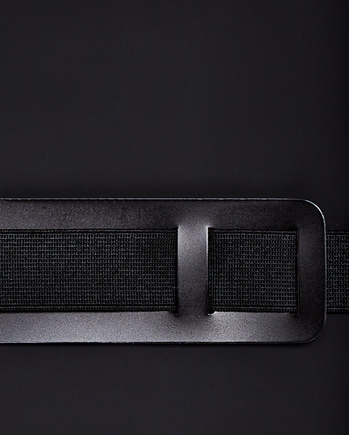 Zbliżenie czarnego paska zapinanego na prostokątną klamrę na tle notatnika voyager m czarny