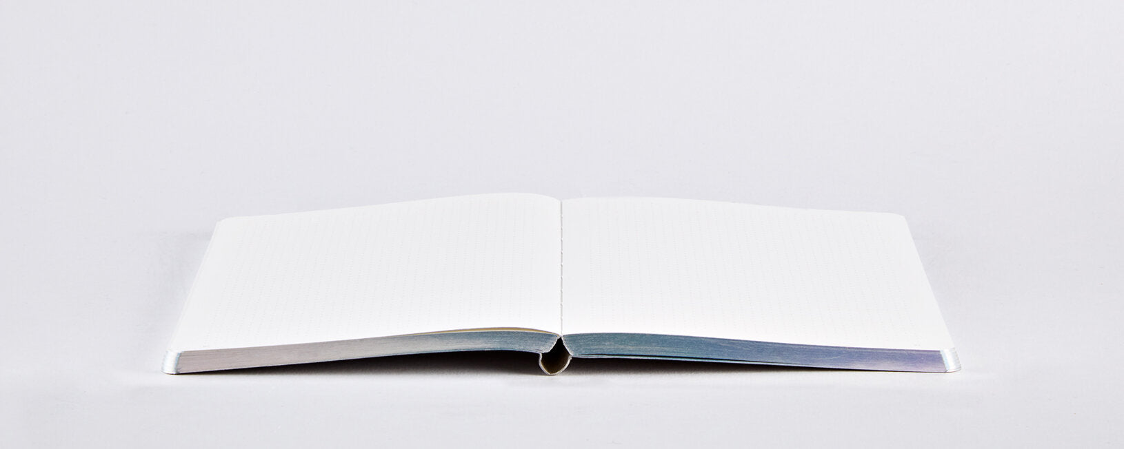 Notatnik fluid chrome BV JACOB COMPANY otwarty na płasko z pustymi białymi stronami