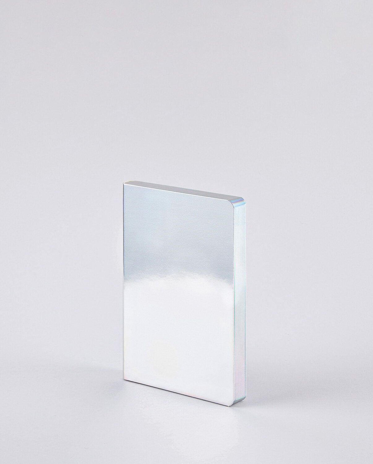 Notatnik Nuuna Fluid Chrome S z lustrzaną, błyszczącą okładką na szarym tle