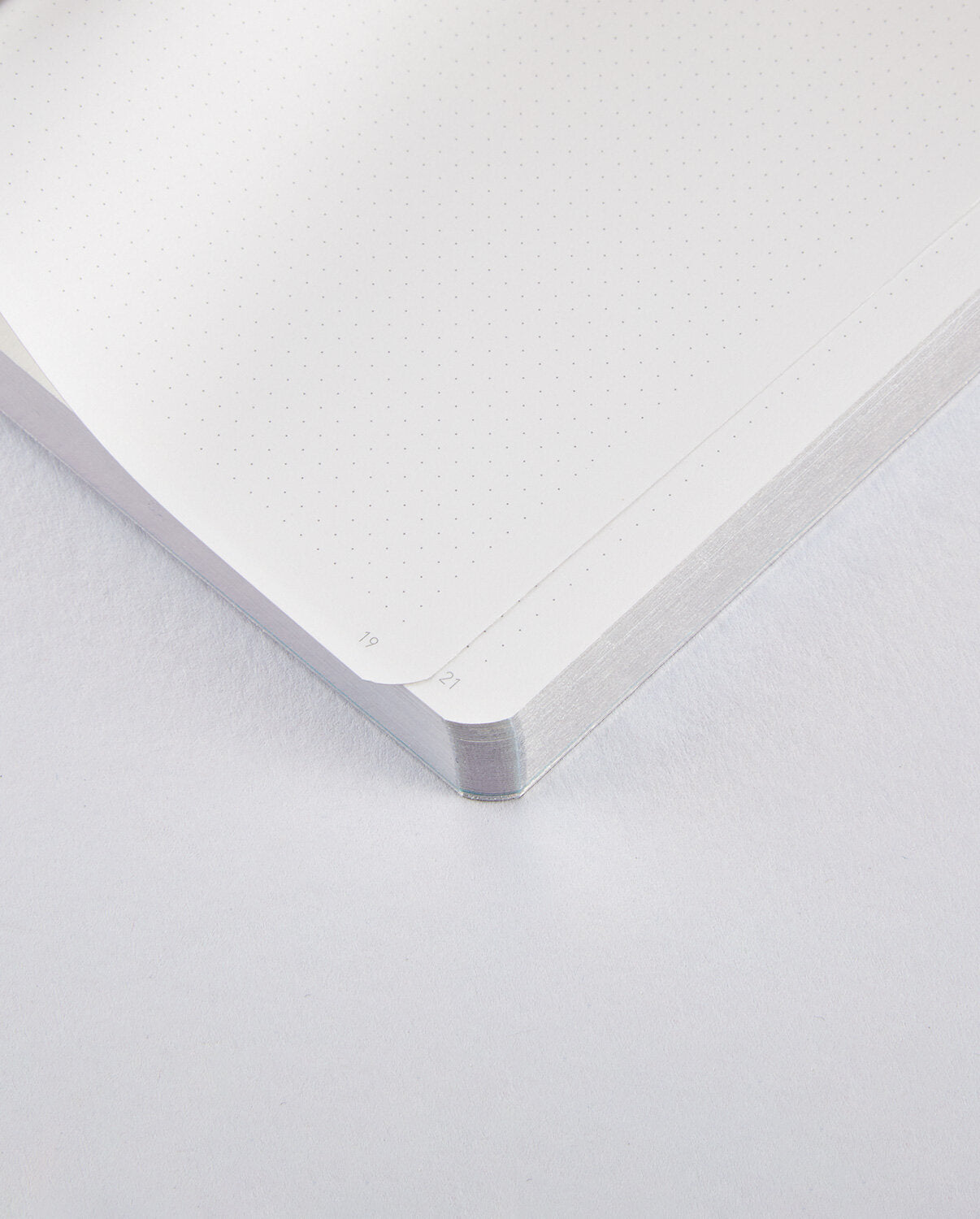 Wnętrze notatnika Nuuna Fluid Chrome S z białymi stronami w kropki i zaokrąglonymi rogami