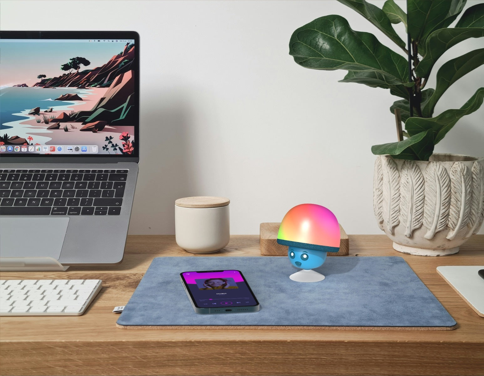 Świecący głośnik bezprzewodowy MOB na biurku obok laptopa i smartfona