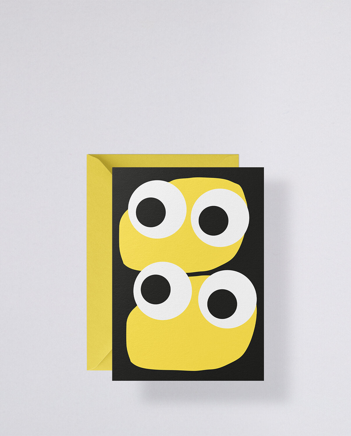 Kartka okolicznościowa Jim z żółtymi kształtami i dużymi białymi oczami na czarnym tle z żółtą kopertą