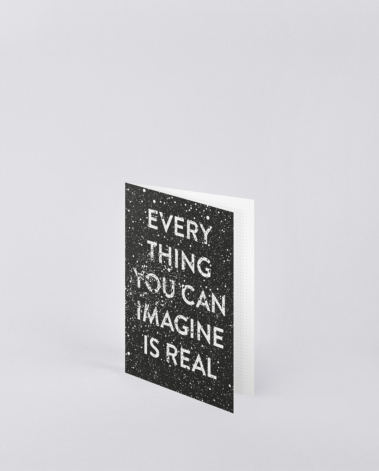 Czarna kartka okolicznościowa z cytatem Everything You Can Imagine Is Real na białym tle