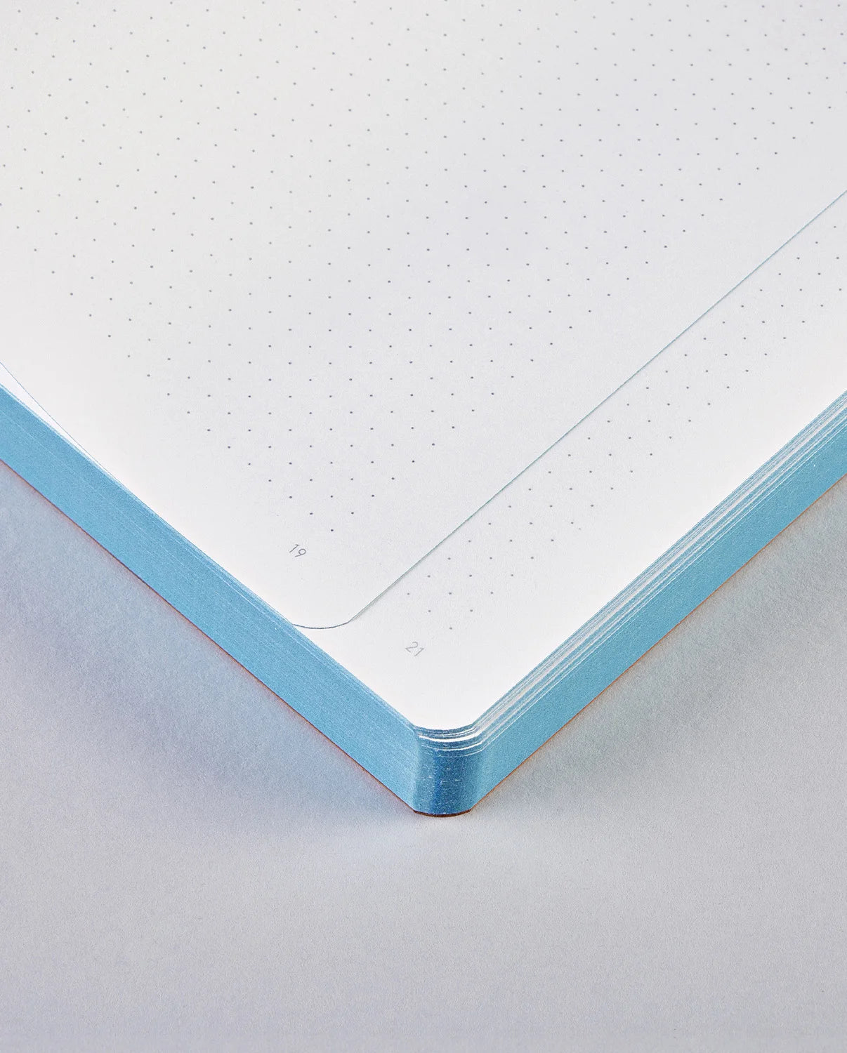 Niebieski notatnik Graphic L Unconditional Love z kartkami w kropki i zaokrąglonymi rogami