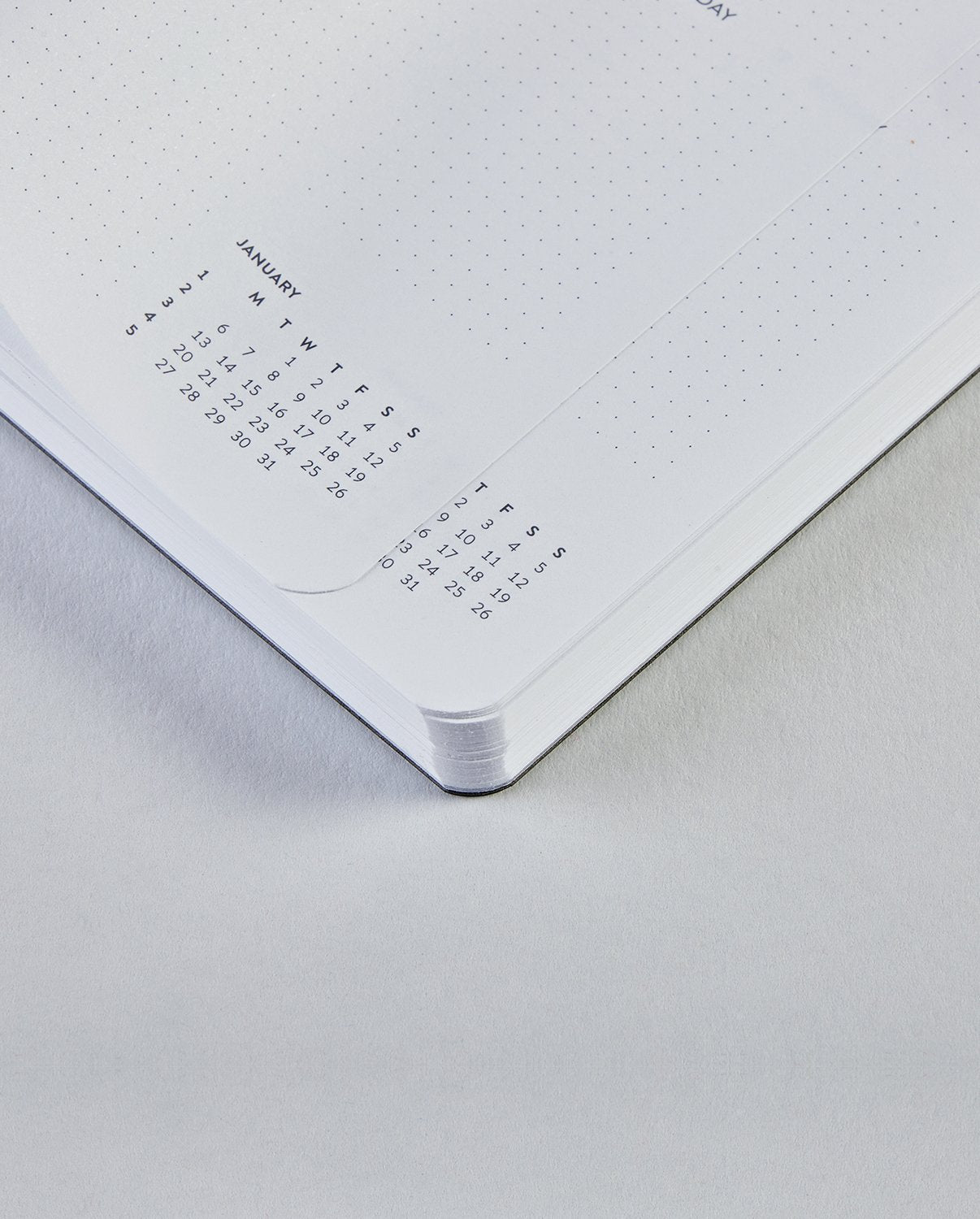 Kalendarz tygodniowy 2025 z małymi mini kalendarzami miesięcznymi na białych kartkach