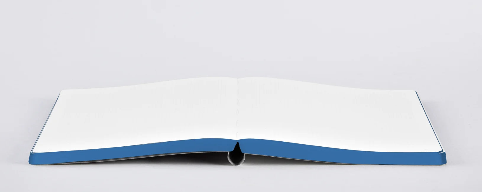 Otwarty notatnik Where Is My Mind z białymi kartkami i niebieską oprawą na płaskiej powierzchni