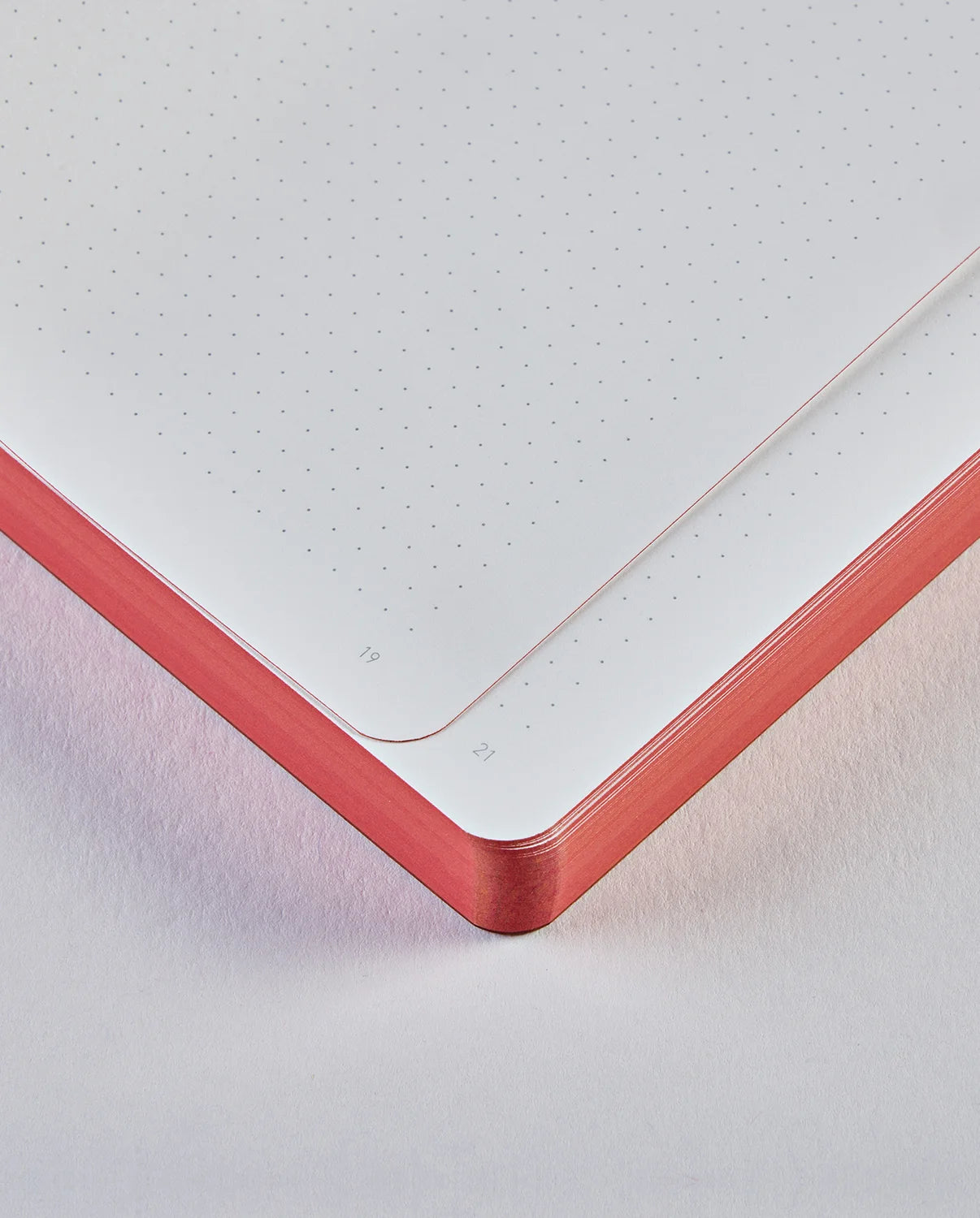 Zbliżenie na rogi stron w notatniku truths & dares z czerwonymi brzegami papieru