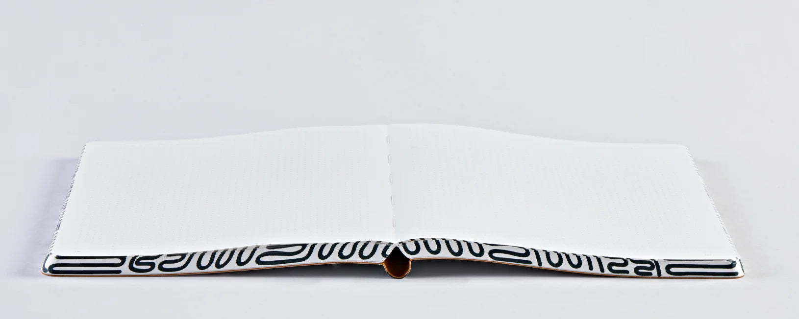 Otwarty notatnik graficzny Miracle firmy BV JACOB COMPANY z białymi stronami na szarym tle