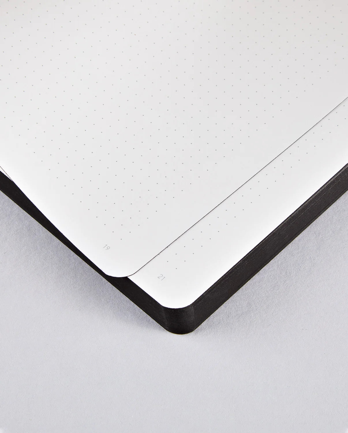 Notatnik w kratkę sassy squares z czarną oprawą otwarty na dwóch stronach z zaokrąglonymi narożnikami