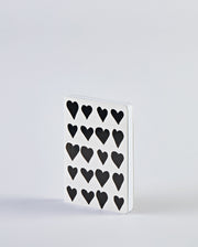 Notatnik z sercami o białej okładce z czarnymi wzorami serc od BV JACOB COMPANY