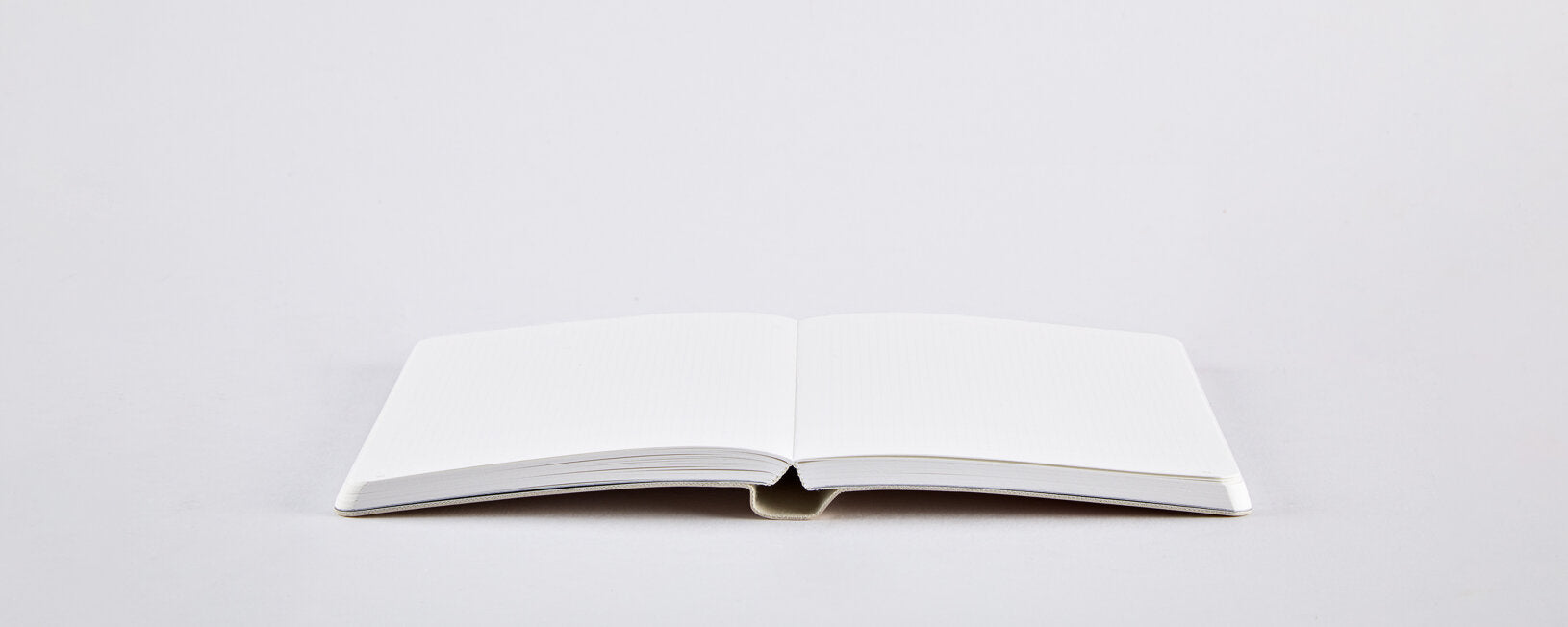 notatnik Bébé Sucré S otwarty na białym tle z pustymi białymi stronami