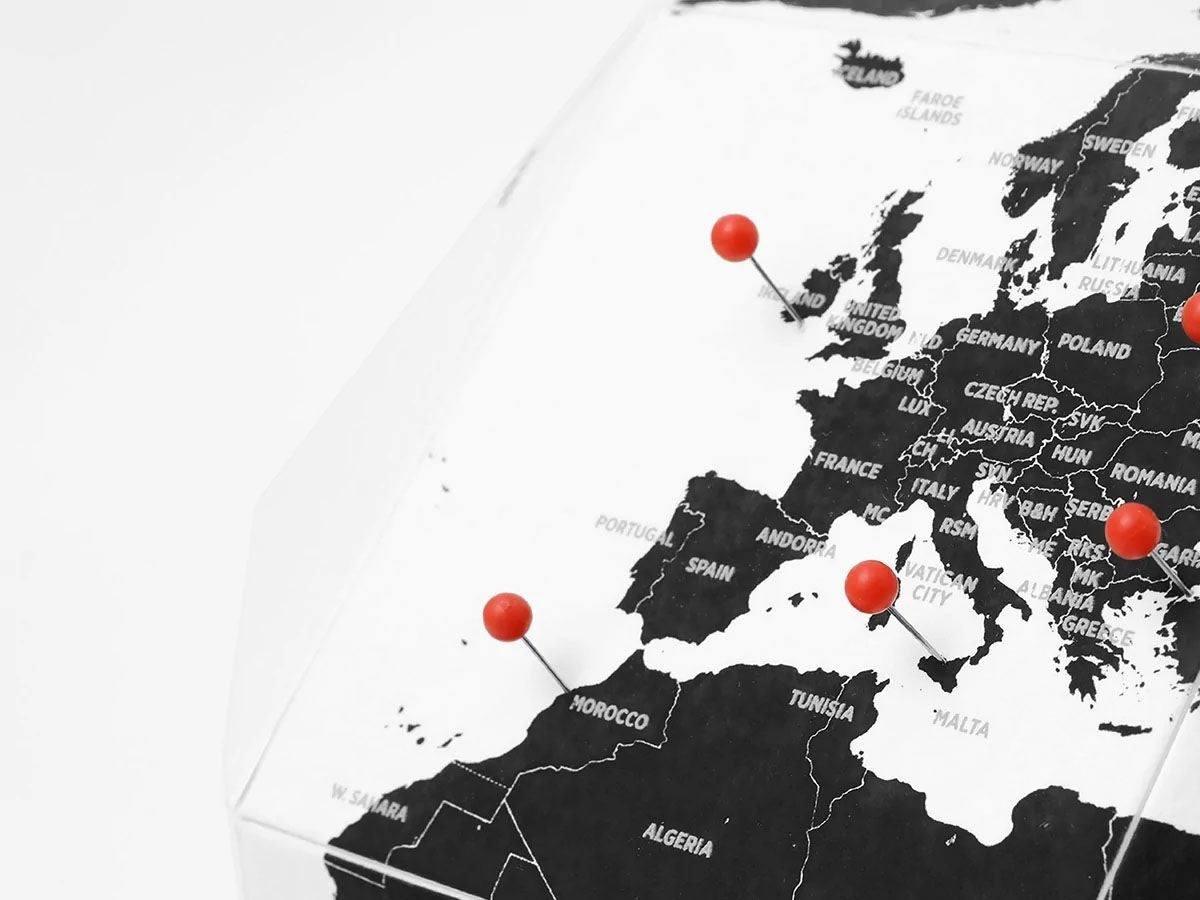 Globus z pinezkami do oznaczania krajów na mapie Europy i północnej Afryki
