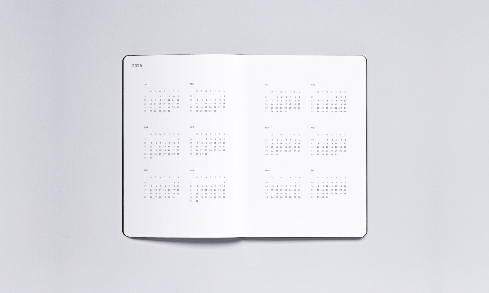 Minimalistyczny kalendarz tygodniowy 2025 otwarty na białych stronach z czarnym nadrukiem BV JACOB COMPANY