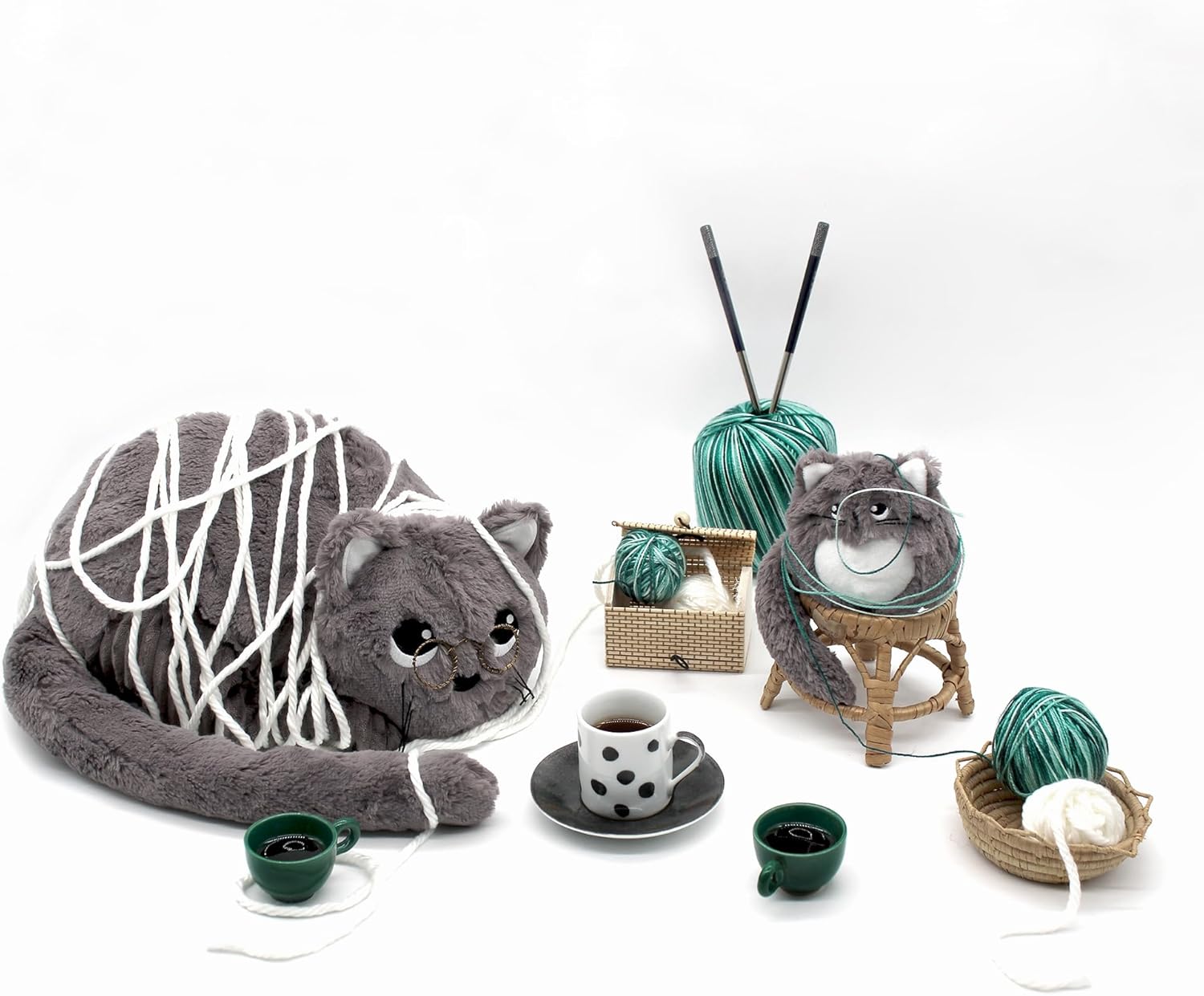 Pluszowy kot mama i dziecko z motkami włóczki i filiżankami kawy na białym tle
