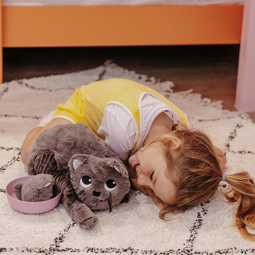 pluszowy kot mama i dziecko z miękkiego materiału obok uśmiechniętej dziewczynki leżącej na dywanie