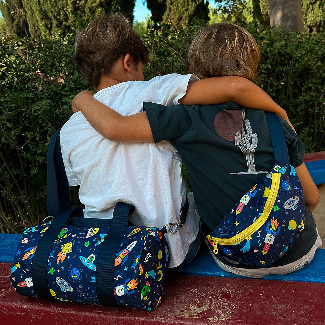 Nerka dziecięca z motywem kosmosu Yamann noszona przez chłopca siedzącego na ławce obok torby podróżnej