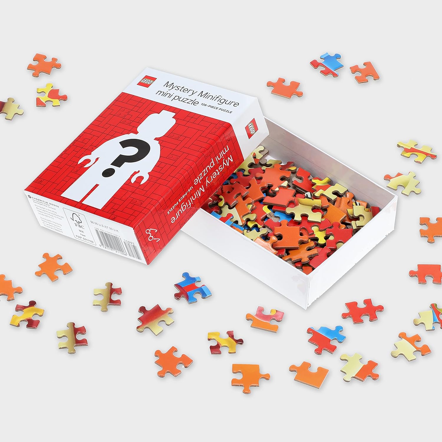 Minipuzzle LEGO z motywem tajemniczej minifigurki w otwartym pudełku z kolorowymi elementami