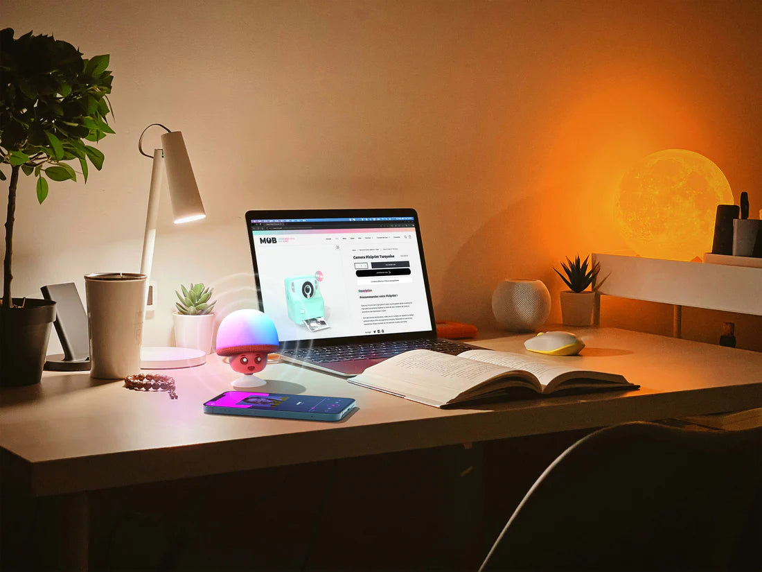 Świecący głośnik bezprzewodowy MOB w kształcie grzyba na biurku z laptopem i lampą