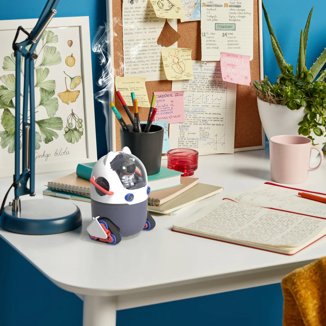 Nawilżacz powietrza Space Humy na biurku obok lampy, notesów i rośliny w doniczce