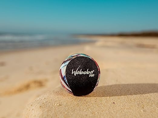 Kolorowa piłeczka Waboba Pro do odbijania na wodzie ustawiona na piasku na plaży