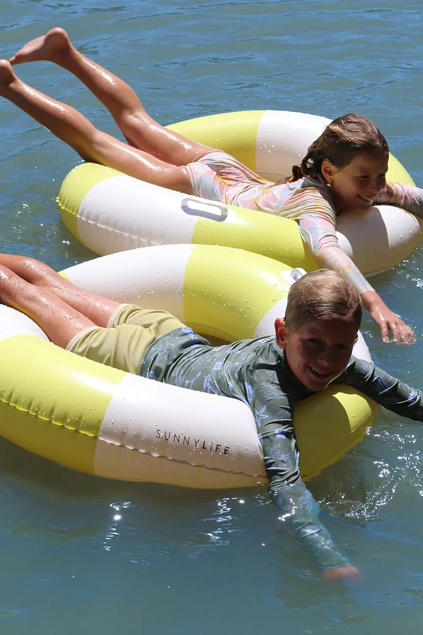 Dzieci bawiące się na wodzie na jasnozielono-białym kole do pływania dla dorosłych marki LOQI