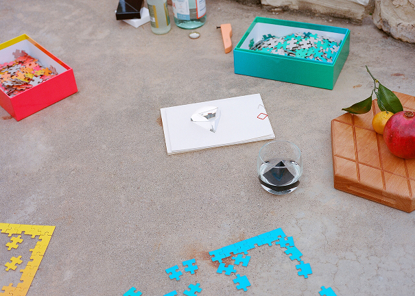 Szklanka z kostkami do napojów design na stole otoczonym puzzlami i owocami