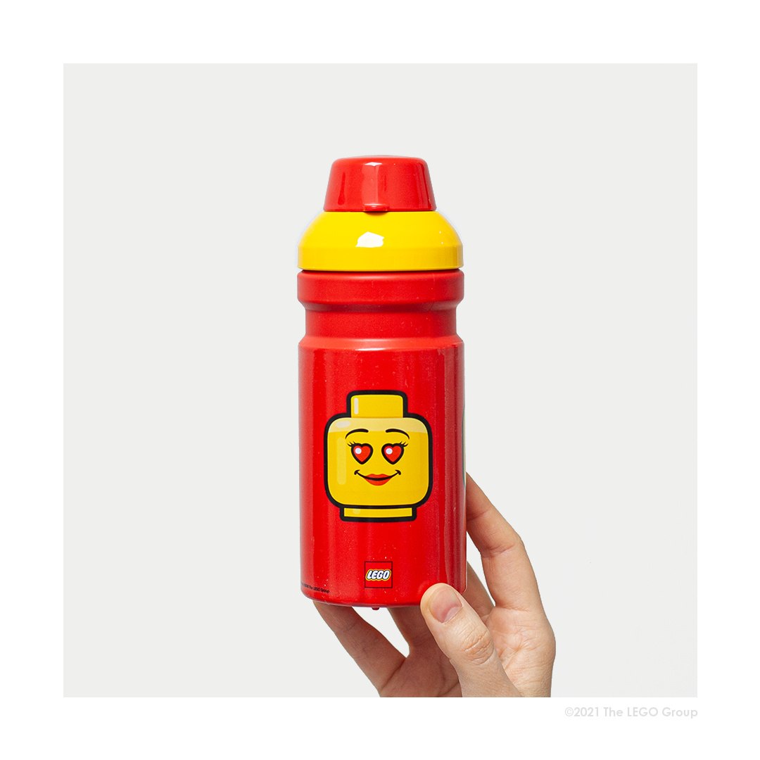 czerwony bidon LEGO dla dziewczynki z uśmiechniętą główką LEGO w ręce