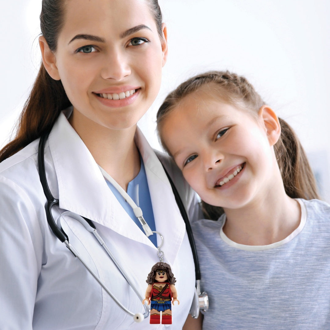 Brelok Wonder Woman LEGO zawieszony na identyfikatorze lekarza z uśmiechniętą dziewczynką