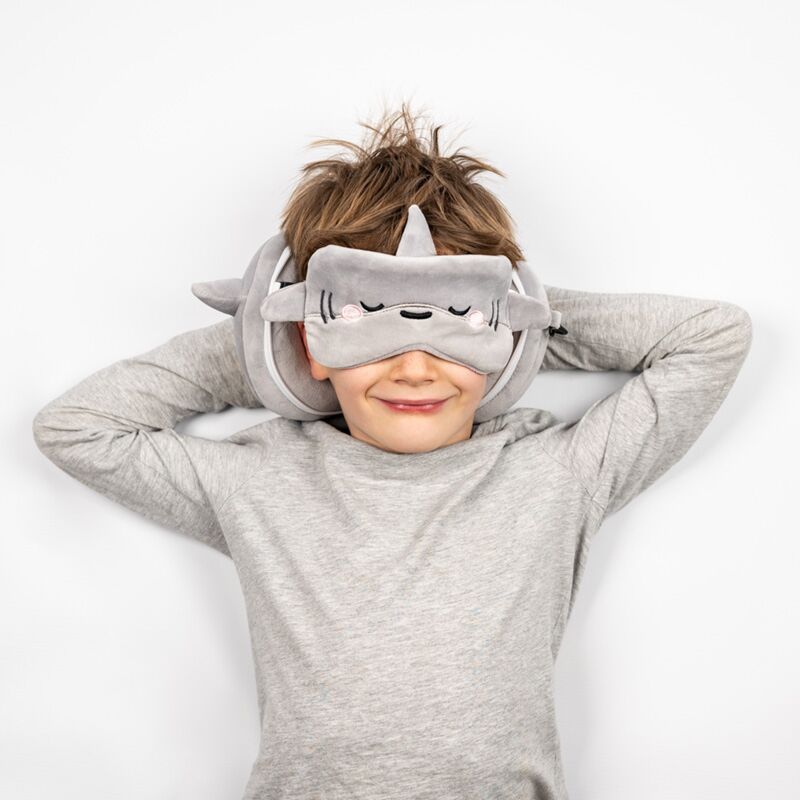 Pluszowa poduszka podróżna rekin Puckator w szarym kolorze na szyi uśmiechniętego chłopca